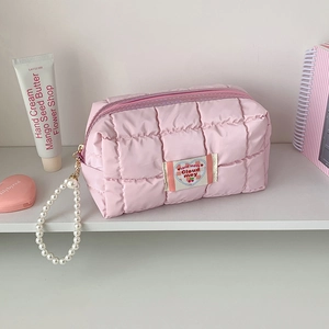 Dettaglio della borsa trapuntata rosa con manico in perline e chiusura a zip sicura
