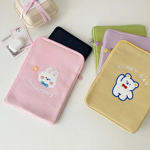 Detailed close-up of corduroy iPad sleeve featuring cute animal embroidery and zip closure