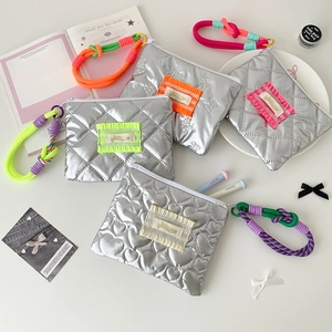 Mini pochette matelassée argentée avec poignée tissée colorée et détails de volant