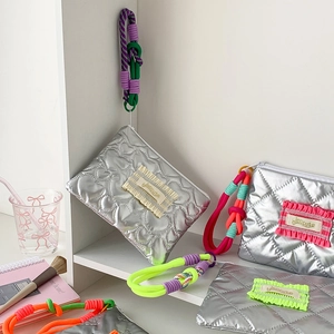 Trousse à maquillage matelassée argentée avec motifs de cœur et cordons tressés colorés