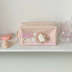 Detail of pink glitter pencil case with keep smile text and furry ball pendant decoration