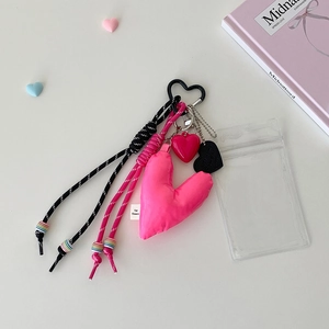 Detail of pink fabric heart charm and woven ropes with heart-shaped carabiner for bags