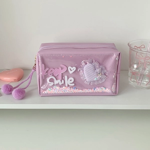Detail of purple pencil case with glitter sequins, star charms and twin pompom zipper