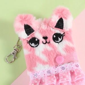 Close-up of a cute plush cat pendant with pink lace skirt and metal lobster clasp