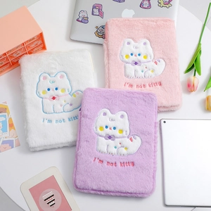 Three plush cartoon cat laptop sleeves in white, pink, and purple on a tidy desk