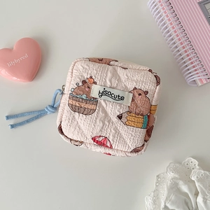 Detalle de la bolsa de almacenamiento de tela acolchada rosa con lindo diseño de capibara
