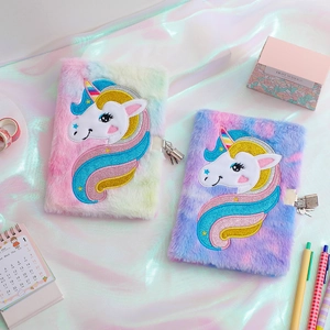 Dettaglio di taccuini unicorno in peluche con ricamo arcobaleno e serrature in metallo