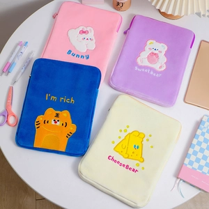 Detail showing plush tablet sleeves with cartoon embroidery in four soft colors