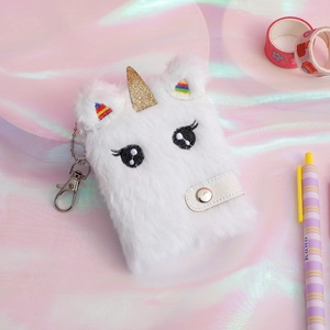 Dettaglio del taccuino in peluche a forma di unicorno con corno dorato e clip