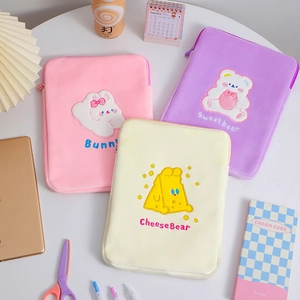 Detailed view of three cartoon plush tablet sleeves in pink, purple, and cream white colors