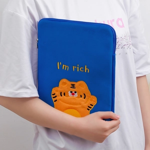 Detail of blue plush tablet sleeve featuring cute orange tiger embroidery and rich text