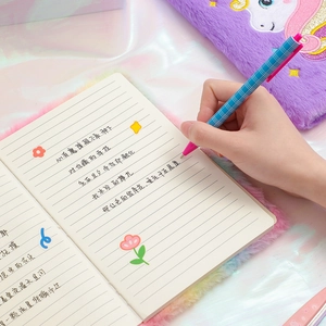 Detail of plush unicorn notebook with gradient faux fur and matching checkered ballpoint pen