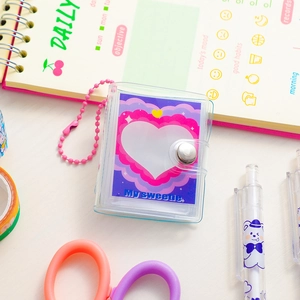 Detail of mini transparent 2-inch photo album with pink heart pattern and snap closure