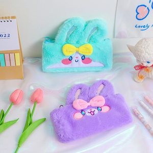 Detail of plush bunny pencil cases featuring soft fur texture and cute bow decorations