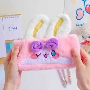 Pink plush rabbit pencil case with cute 3D ears and embroidery in a cozy setting