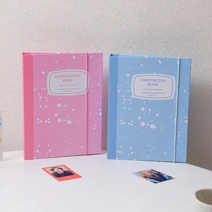 Detailed view of pink and blue A5 loose-leaf binders with elastic bands on a white desk