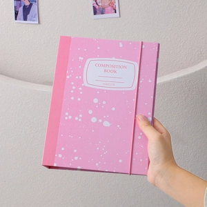 Close-up of pink composition book with white ink splatters and elastic strap closure