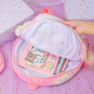 Détail de l'intérieur du sac à dos licorne en peluche avec cahiers et fournitures