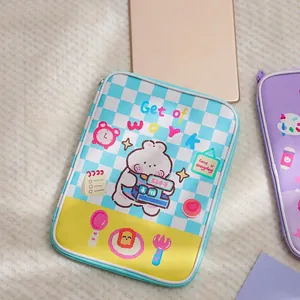 Close-up of blue checkerboard iPad sleeve with cute cartoon bear driving a bus