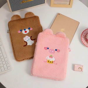 Primer plano de fundas de felpa para iPad con bordados de oso y cerdito y textura muy suave