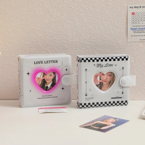 Detail of heart-shaped cutout mini photo albums with snap closure and grid patterns