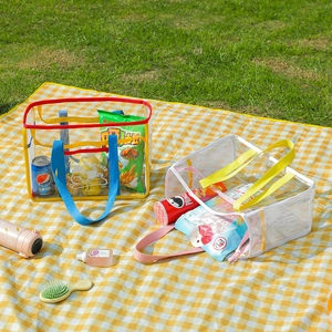 Detail of transparent PVC tote bag with colorful ribbon edges and cloud illustrations