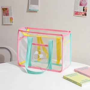 Close-up of pink clear PVC shoulder bag with cartoon pattern and yellow mesh side