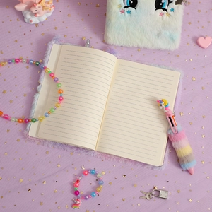 Coffret journal licorne en peluche avec stylo et bijoux sur fond pailleté violet