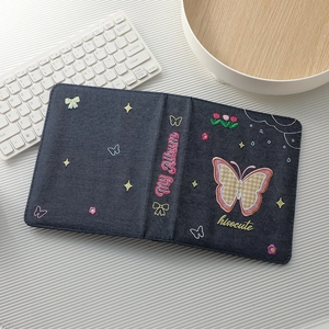 Detail of blue denim A5 photo album with colorful butterfly embroidery and My Album text