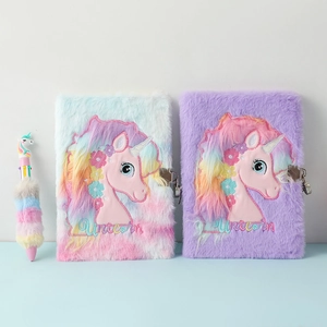 Detail of plush unicorn A5 notebooks with metal locks and matching multi-color pen set