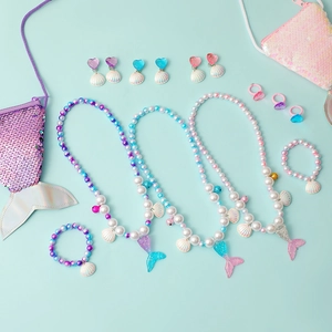 Detailed set of mermaid theme jewelry featuring beaded necklaces and seashell pendants