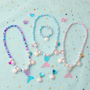 Detail of mermaid themed jewelry set with pearl beads and shell pendants for girls