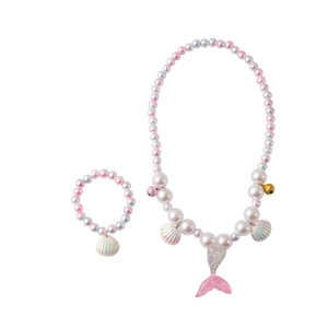 Detail of mermaid tail charms and colorful gradient pearls on a kids jewelry set
