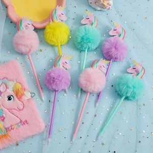 Dettaglio di un taccuino unicorno di peluche ricamato con penne unicorno con pompon