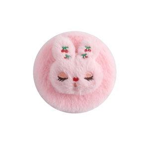 Detail of pink plush hand mirror with cute embroidered rabbit face and cherry accents