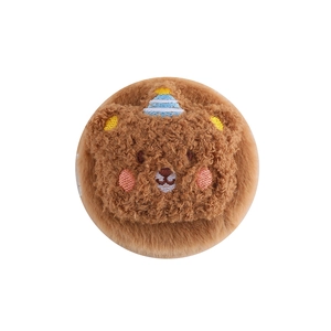 Detail of cute brown plush bear head with embroidery and blue party hat decoration