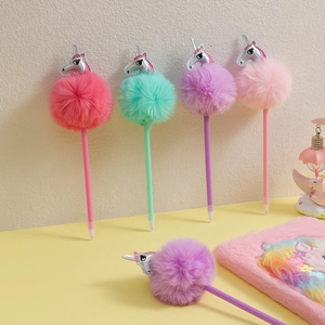 Close-up of fluffy pom-pom pens with unicorn motifs in pink, blue, and purple tones