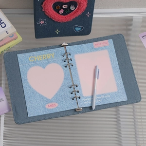 Close-up of Y2K denim A5 binder showing heart-shaped photo slots and inner details