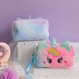 Detailed view of plush unicorn makeup bags with gradient fur and glitter ears on a display stand