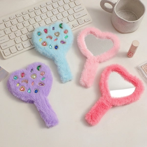 Macro shot of heart-shaped handheld mirrors with plush handles and colorful faux gemstones