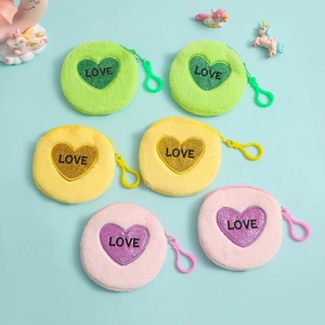 Detail of macaron-colored plush coin purses with LOVE heart patches and hanging hooks