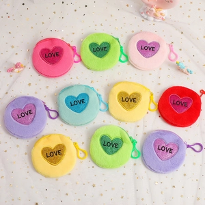 Detailed view of colorful plush coin purses with heart LOVE embroidery and carabiner clips
