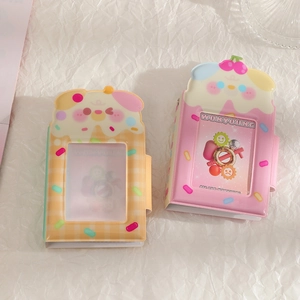 Flat lay detail of cartoon puppy and cake photocard albums on a wrinkled white background