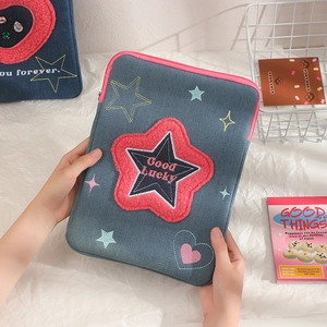 Detail of denim iPad sleeve featuring plush pink star with Good Lucky embroidery