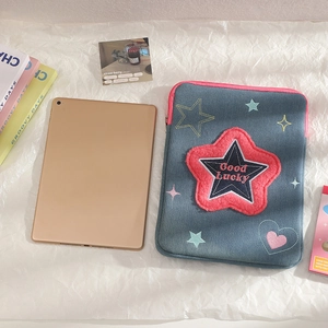 Detailed view of denim iPad sleeve with pink star embroidery and Good Lucky patch decoration