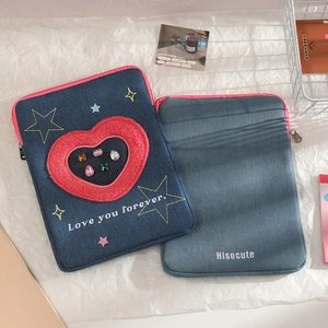Dettaglio custodia iPad in denim con cuore di peluche rosso e ricami a stella