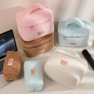 Detail of plush makeup bag showing soft texture and convenient top handle in pink and beige