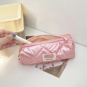 Detailed view of pink quilted fabric pencil case with glossy finish and zip closure