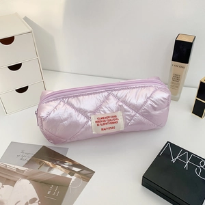 Detailed view of light purple quilted pencil case with metallic finish and woven label