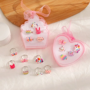 Detail of adjustable cartoon rings set with glitter unicorns and cats in a pink gift box